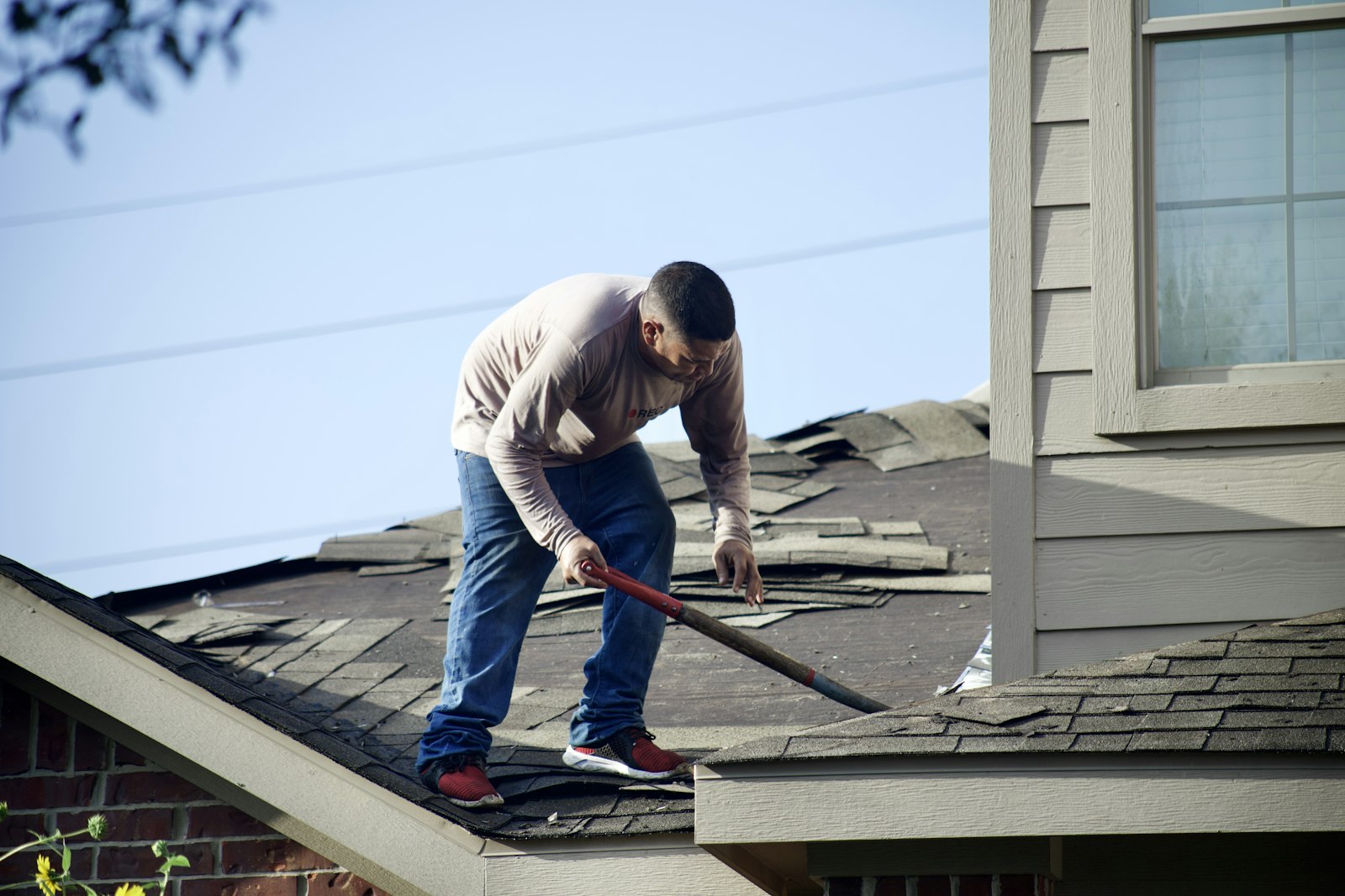 Roofer replacing shingles on a home.